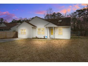Charming single-story home with white siding and a well-maintained front yard at dusk at 311 Macgregor Dr, Summerville, SC 29486