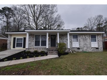 Charming single-story home with a well-manicured front yard and a classic brick facade at 338 Holly Ave, Goose Creek, SC 29445