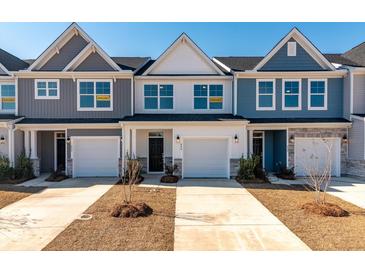 Charming townhomes boast unique colors, stone accents, attached garages and bright windows, creating a welcoming curb appeal at 404 Duskywing Dr, Goose Creek, SC 29445