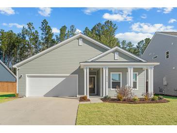 Charming home featuring a manicured lawn, attached garage, and a covered front porch at 4316 Cotton Flat Rd, Summerville, SC 29485