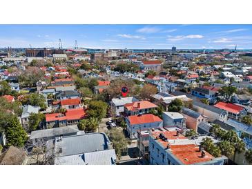 Charming Charleston single home boasts a vibrant red roof and overlooks a picturesque cityscape with a distant bridge view at 45 Bogard St, Charleston, SC 29403