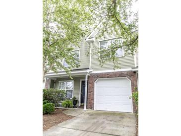 Charming two-story home featuring a brick-accented garage and inviting front porch with lush landscaping at 5208 Fernland Way, North Charleston, SC 29420