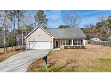 Charming one-story home featuring a well-manicured front yard and an attached two-car garage at 144 Cinnamon Rd, Summerville, SC 29483