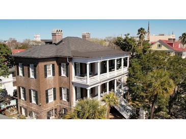 Stunning exterior view of a historic home, showcasing balconies, columns, and surrounding foliage at 214 Calhoun St # 5, Charleston, SC 29401