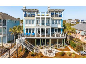 Stunning coastal home featuring multi-level decks, a fire pit, and panoramic ocean views, perfect for luxurious outdoor living at 511 W Ashley Ave, Folly Beach, SC 29439