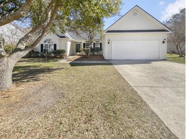 Charming one-story home features an attached two-car garage, well-maintained lawn, and mature trees at 5509 Copper Trce, North Charleston, SC 29418