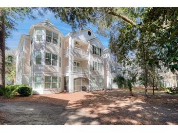 Beautiful exterior shot of a multi-level condo with balconies and attractive architectural design, surrounded by mature trees at 60 Fenwick Hall Aly # 622, Johns Island, SC 29455