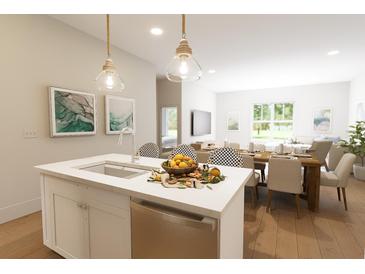 Bright open concept kitchen with stainless steel appliances and eat-in island flowing into dining area at 7631 Indigo Palms Way, Johns Island, SC 29455