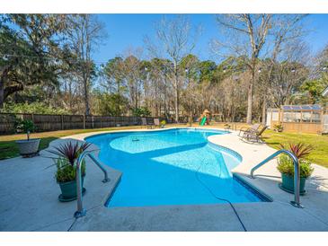 Inviting in-ground pool with a diving board, lounge chairs, and lush landscaping at 8512 Kennestone Ln, Charleston, SC 29420