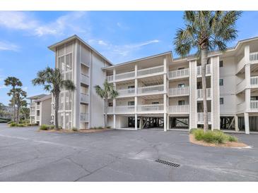 Coastal condo building with multi-level decks, palms, and covered parking at 2017 Long Bend Dr, Seabrook Island, SC 29455
