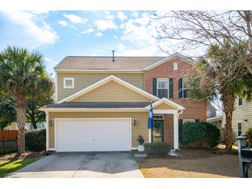 Charming two-story home boasts a combination of tan siding and brick, complete with an attached two-car garage at 225 Nelliefield Creek Dr, Wando, SC 29492