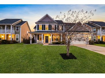Charming two-story home featuring a well-manicured lawn and inviting front porch with white columns at 402 Spectrum Rd, Summerville, SC 29486