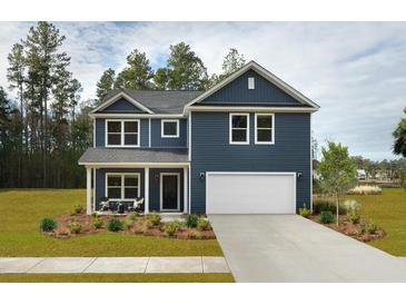 Two-story home with blue siding, covered porch, two-car garage, and well-manicured lawn at 641 Cottage Landing Dr, Summerville, SC 29485
