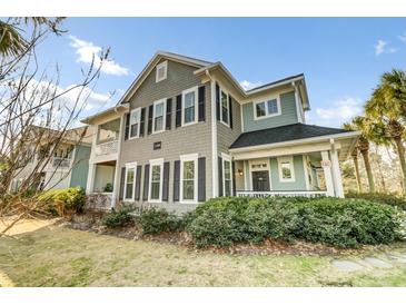Charming two-story home showcasing a covered front porch and lush landscaping at 1225 Blakeway St # 1104, Daniel Island, SC 29492