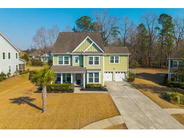 Charming two-story home with green siding, well-manicured lawn, and two car garage at 136 Stagecoach Ln, Summerville, SC 29483