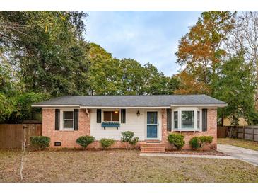 Charming brick home with a blue front door, decorative window box, and black shutters at 1491 Seacroft Rd, James Island, SC 29412