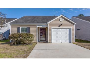 Charming single-story home with a well-maintained yard and attached garage on a sunny day at 152 Coosawatchie St, Summerville, SC 29485