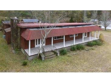Rustic home featuring a covered porch with white pillars and red siding at 609 Levee Dr, Moncks Corner, SC 29461