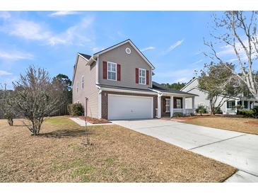 Charming two-story home featuring a two car garage, red shutters, and a well-maintained lawn at 105 Waylon Dr, Summerville, SC 29483
