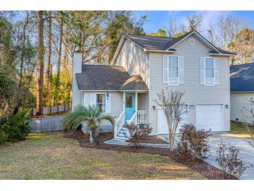 Charming two-story home featuring a light blue front door, light beige siding, and a well-manicured front yard at 1253 Lakefront Dr, Charleston, SC 29412