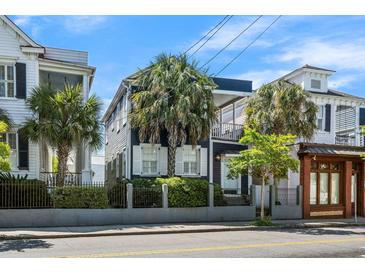 Charming two-story home featuring a small balcony, palm trees, and beautiful landscaping at 167 Spring St # A/B, Charleston, SC 29403
