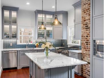 Well-lit kitchen features a large island, stainless steel appliances, and grey cabinets at 25 Logan St, Charleston, SC 29401