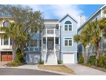 Charming two-story beach home featuring a double front porch, light blue siding, and dual garage doors at 27 Ocean Point Dr, Isle of Palms, SC 29451
