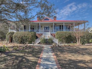 Charming two-story home with a red roof, brick pathway, covered porch, and landscaped front yard at 547 Island Walk, Mount Pleasant, SC 29464