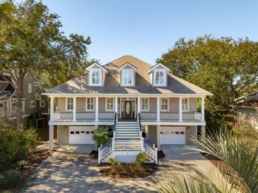 Stunning home with a double porch, grand staircase, three dormer windows, and attached two-car garage at 7 Seahorse Ct, Isle of Palms, SC 29451