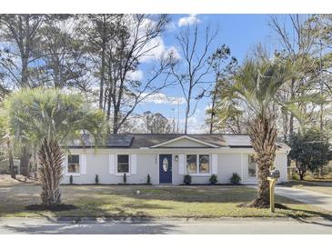 Charming single-story home boasts a manicured lawn and mature trees, creating a welcoming curb appeal at 7629 Vanderbrook Pl, North Charleston, SC 29420