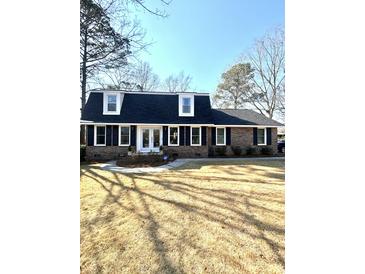 Charming brick home with a well-manicured lawn, black shutters, and a classic white front door at 122 Mellard Dr, Goose Creek, SC 29445