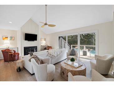 Bright living room featuring a fireplace, vaulted ceilings, and a seamless indoor-outdoor flow to the deck at 2276 Seascape Ct, Seabrook Island, SC 29455
