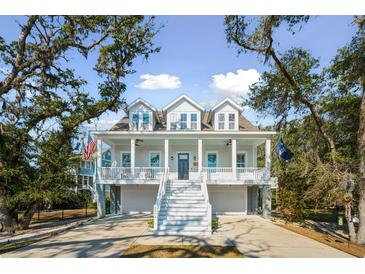 Charming two-story home featuring a double front porch, white railings, and a ground-level garage at 2514 Bullock Guard Dr, Johns Island, SC 29455