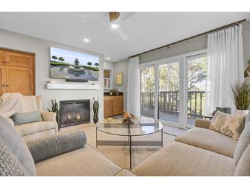 Inviting living room with fireplace, flat-screen TV, and sliding doors to a private balcony at 409 Yacht Harbor Ct # 409, Isle of Palms, SC 29451