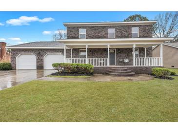 Two-story brick home featuring a spacious porch, two-car garage and well manicured lawn at 828 Longbranch Dr, Charleston, SC 29414