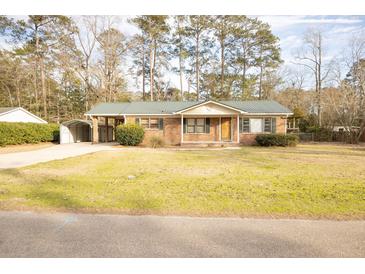 Charming brick home featuring a metal roof, carport, and spacious front yard at 105 Pinewood St, Walterboro, SC 29488