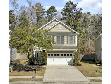 Charming two-story home with a two-car garage, mature trees, and a well-maintained lawn at 110 Instructor Ct, Ladson, SC 29456