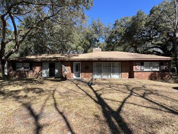 Charming brick ranch-style home with mature trees and covered front porch at 111 Newington Rd, Summerville, SC 29485