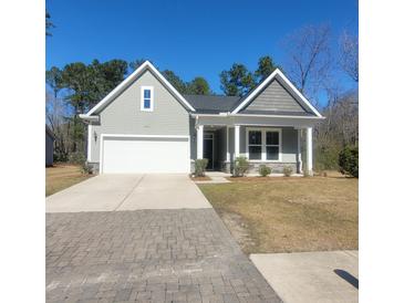 Charming gray home with a two-car garage and well-manicured lawn at 113 Doral Blue Dr, Summerville, SC 29483