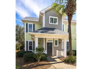 Charming exterior view of a two-story townhome with a covered porch and lush landscaping at 1225 Blakeway St # 403, Charleston, SC 29492