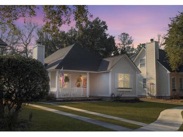Charming single-story home with a quaint porch, well-manicured lawn, and welcoming curb appeal under a colorful sky at 2320 Chadbury Ln, Mount Pleasant, SC 29466
