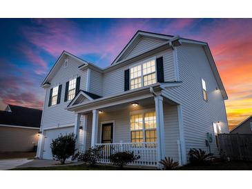 Charming two-story home featuring classic siding, black shutters, and a welcoming front porch at sunset at 615 Ravens Wood Rd, Summerville, SC 29486