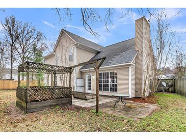 A charming backyard featuring a wooden pergola, patio, and lush landscaping at 113 Hartley Hall Ct, Summerville, SC 29485