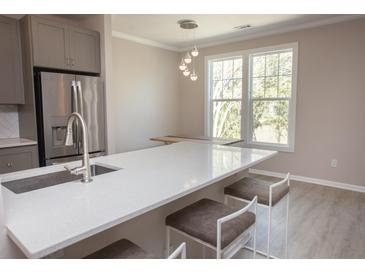 Bright kitchen features stainless steel appliances, gray cabinetry, white countertops, and a breakfast bar with seating at 130 River Landing Drive # 8209, Charleston, SC 29492