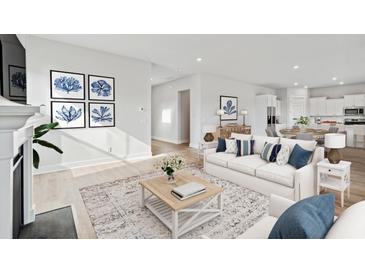 Bright living room with white sofa, blue pillows, light wood floors, fireplace, and decor at 231 Denham St, Summerville, SC 29486