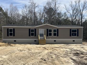 Charming one-story home with tan siding, black shutters, and a neatly maintained front yard, awaiting landscaping at 286 Marion Rd, Dorchester, SC 29437