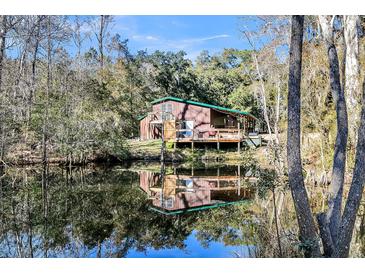 Charming home reflects on the water, surrounded by trees at 5219 Maybank Hwy, Wadmalaw Island, SC 29487