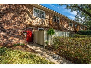 Charming townhome with brick and wood exterior and a vibrant red front door at 607 Saint Charles Ct, Charleston, SC 29407