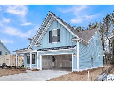 Beautiful, light blue home features an attached two-car garage, a covered porch, and a gabled roof at 429 Grove End Rd, Moncks Corner, SC 29461