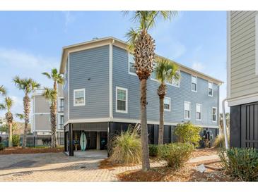 Coastal home featuring a raised foundation, blue siding, and palm trees adding a touch of tropical charm at 9 J C Long Blvd, Isle of Palms, SC 29451